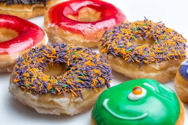 Çörekler Beyaz Arkaplanda İzole Edildi. Farklı tipte donutlar elde edersiniz: çikolata, pembe, çizgili, şuruplu ve şeker tozlu..