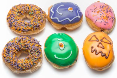 Çörekler Beyaz Arkaplanda İzole Edildi. Farklı tipte donutlar elde edersiniz: çikolata, pembe, çizgili, şuruplu ve şeker tozlu..