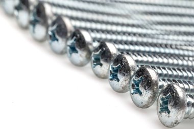 metal background with different screws on white background 