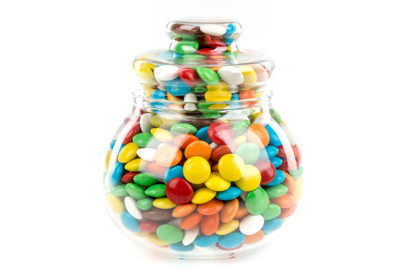 colorful candies in a glass bowl on a white background