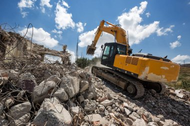 Working crawler excavator digging at construction site during demolition detached house