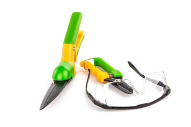 green plastic scissors on a light background. the secateurs on a white isolated