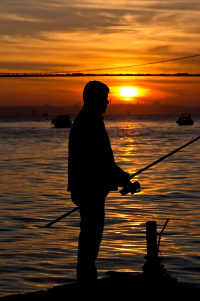 Gün Batımında Elinde Olta Olan Bir Balıkçının Silueti — Stok fotoğraf