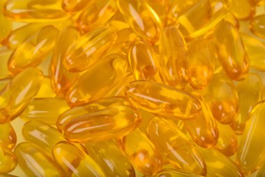 Beyaz arka planda sarı balık yağı kapsülleri