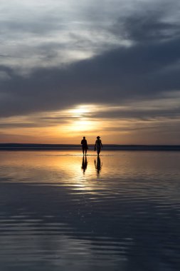 Gün batımında sahilde bir çift.