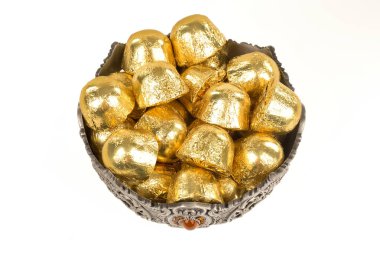 Beyaz arka planda izole edilmiş metal tabaktaki folyo kaplı çikolata şekerleri.