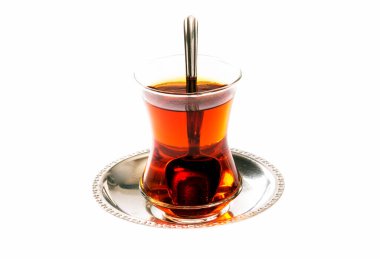 Beyaz arka planda Türk çayı ve kaşık.