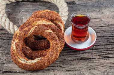 Kahvaltı için ahşap zemin üzerinde Türk Simit 'i. Türk simidi (simit, gevrek) ve çay. 