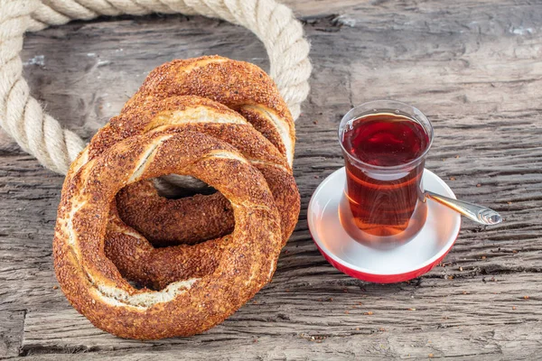 Kahvaltı için ahşap zemin üzerinde Türk Simit 'i. Türk simidi (simit, gevrek) ve çay. 