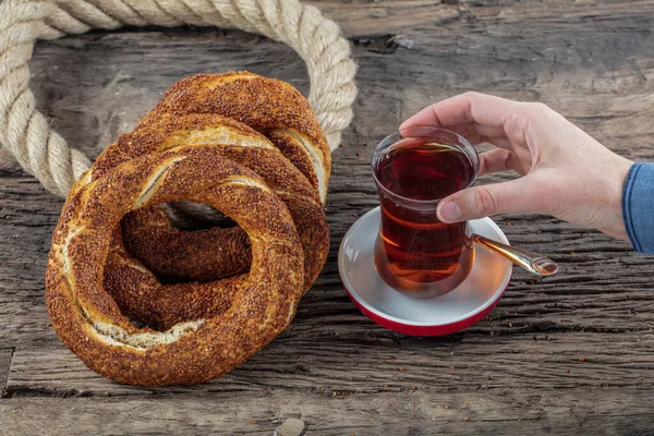 Kahvaltı için ahşap zemin üzerinde Türk Simit 'i. Türk simidi (simit, gevrek) ve çay. 