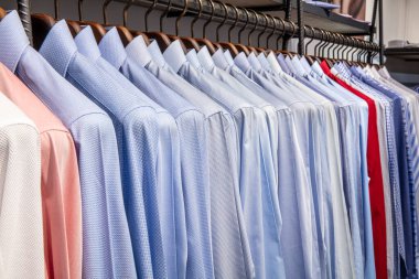 Elbise askısı renkli kumaş gömleklerle dolu. Erkek gömleği mağazası..