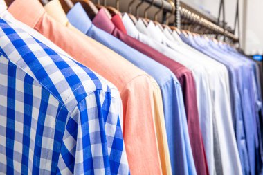 Elbise askısı renkli kumaş gömleklerle dolu. Erkek gömleği mağazası..