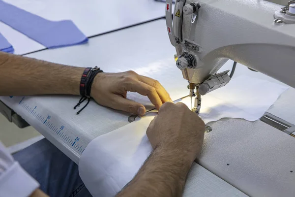 Sewing process of the shirt sewing workshop. old Man's hands behind sewing. Shirt sewing workshop. textile vintage sewing industrial.