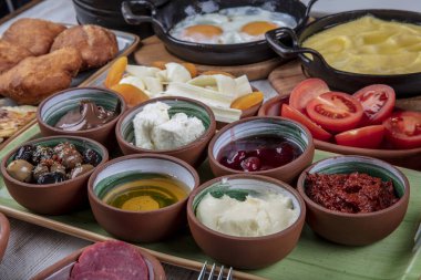 Hafta sonu Türk usulü kahvaltı masası. Seçici odaklanma. Tost, zeytinyağı, kızarmış yumurta, salatalık, reçel, domates sosu, peynir, Türk çayı, zeytin, biber. Mutlu bir aile kahvaltı yapıyor, iyi vakit geçiriyor..