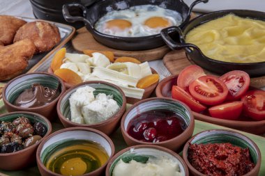 Hafta sonu Türk usulü kahvaltı masası. Seçici odaklanma. Tost, zeytinyağı, kızarmış yumurta, salatalık, reçel, domates sosu, peynir, Türk çayı, zeytin, biber. Mutlu bir aile kahvaltı yapıyor, iyi vakit geçiriyor..