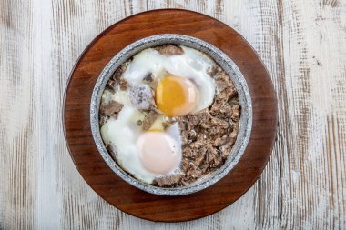 Kavurma ile çırpılmış Türk yumurtası. Ahşap masada kızartılıyor.