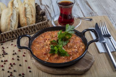 Menemen Türk kahvaltı yumurtası, domates ve biber tavada konsept arka planda.