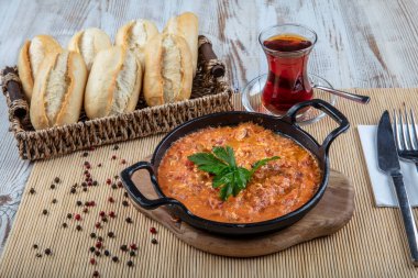 Menemen Türk kahvaltı yumurtası, domates ve biber tavada konsept arka planda.