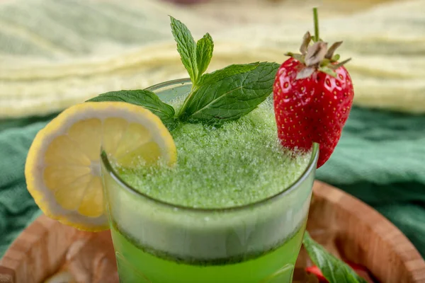 Lemonade with kiwi, green basil, grapefruit syrup and ice, selective focus.