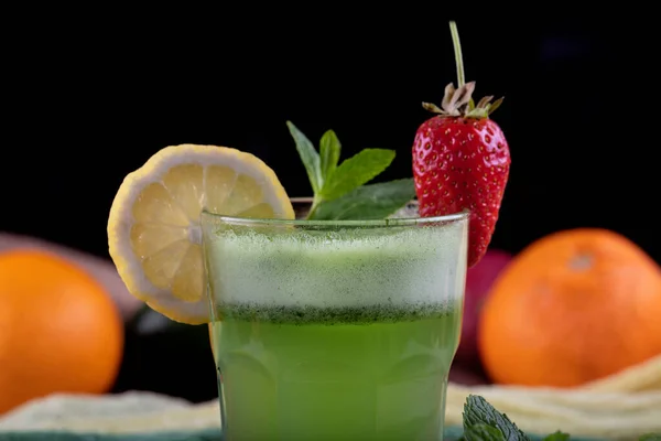 Lemonade with kiwi, green basil, grapefruit syrup and ice, selective focus.