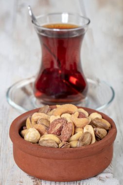 Eski bir kırsal masada fındık ve kurutulmuş meyve karışımı. Altın şam fıstığı, fındık, badem, çay. Gıda arkaplanı.