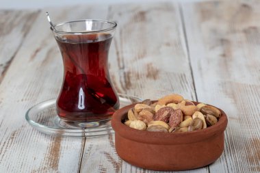 Eski bir kırsal masada fındık ve kurutulmuş meyve karışımı. Altın şam fıstığı, fındık, badem, çay. Gıda arkaplanı.