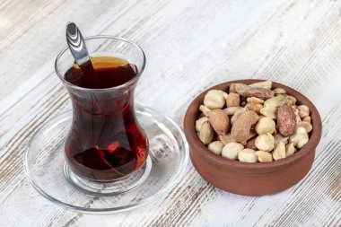 Eski bir kırsal masada fındık ve kurutulmuş meyve karışımı. Altın şam fıstığı, fındık, badem, çay. Gıda arkaplanı.