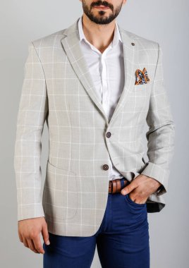 Beyaz bir arka planda ekose ceketli yakışıklı genç adam.