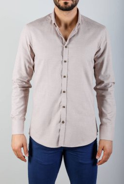 Gri arka planda beyaz gömlekli bir adam.