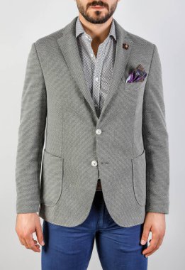 Beyaz arka planda yakışıklı, gri ceketli genç adam.