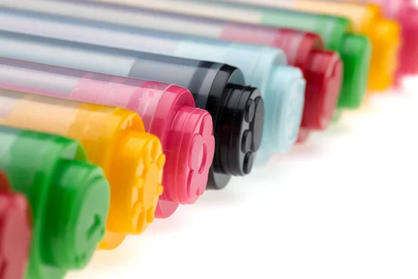 close up of colorful markers on white background