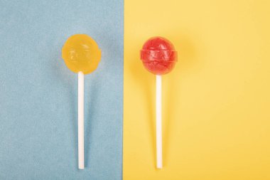 Renkli arkaplanda lolipop şekerlemeleri üst görünümde ve ortada bir lolipop var..