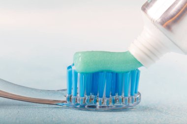 Diş fırçası, diş macunu ve diş macunu tüpüyle bulanık arka planda.