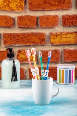 Diş fırçaları seramik bardakta açık arkaplanda masanın üzerinde..
