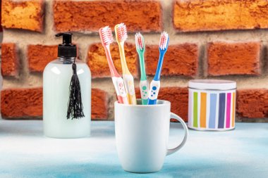 Diş fırçaları seramik bardakta açık arkaplanda masanın üzerinde..