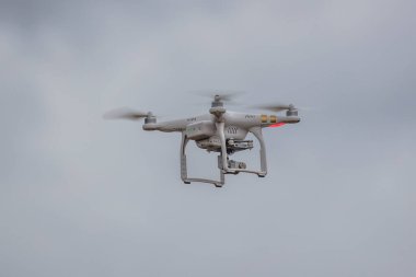 Gri gökyüzünde uçan İHA arka planda