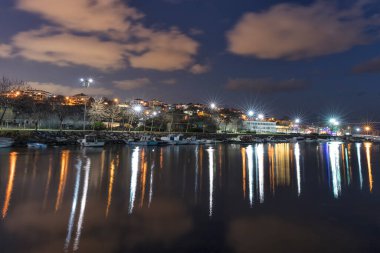Clouds over the harbor at night, seen from the Kucukcekmece, in Cennet Beach, Istanbul.