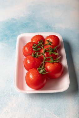 Mavi domatesler üzerinde kırmızı canlı domatesler, yukarıdan.