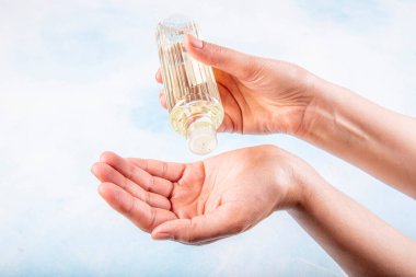 Ellerini parfümle dezenfekte eden bir kız. Dezenfeksiyon ve elinizdeki virüsleri öldürmek için 80 derecelik alkol içeren Türk limon kolonyası.
