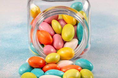 Kahverengi eski ahşap arka planda cam kavanozlarda tatlı şeker şekerlemeleri