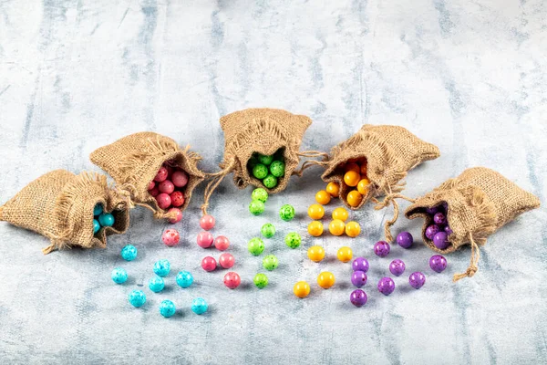 Roasted chickpeas covered in chocolate, fruit sauce. colorful candies, chocolate roasted chickpeas. Colorful starchy roasted chickpea in a linen sack.