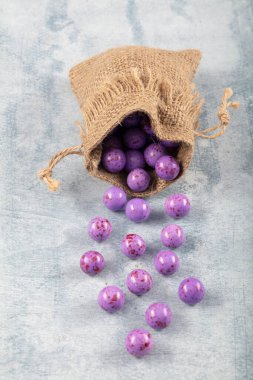 Mor Nohut Şekeri, çikolata kaplı kızarmış nohut, ahşap arka planda keten çuvalında meyve sosu..