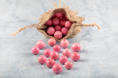 Pembe Nohut şekeri, çikolata kaplı kızarmış nohut, ahşap arka planda keten çuvalında meyve sosu..