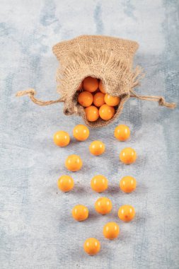 Portakal Şekeri Nohut, çikolata kaplı kızarmış nohut, ahşap arka planda keten çuvalında meyve sosu..