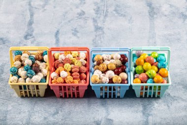 Alışveriş arabasında Candy Nohut, çikolata kaplı kızarmış nohut, ahşap arka planda keten çuvalında meyve sosu.