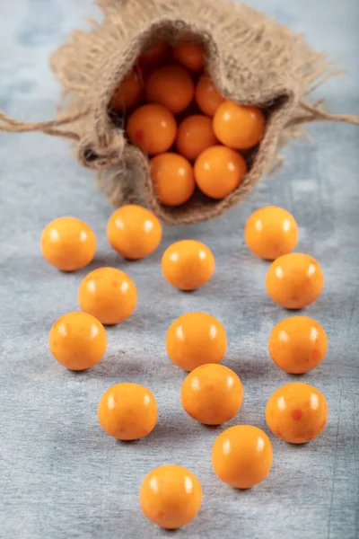 Orange Candy Chickpeas; Roasted chickpeas covered in chocolate, fruit sauce in linen sack on wooden background.