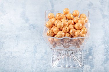 Şeker kasesinde portakal rengi çikolata kaplı fındık ezmesi. Fındıkla dolu renkli çikolata şekerlemeleri.. 