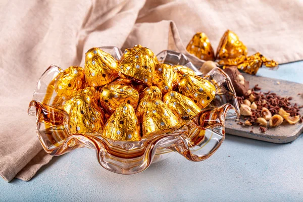 Chocolate candy in shiny wrapper. Delicious chocolate candies  on wooden background. Ramadan Eid (Ramadan feast) Concept.