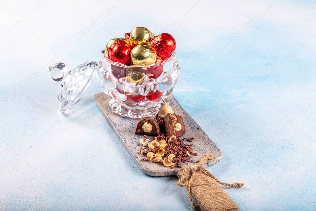 Chocolate candy in shiny wrapper. Delicious chocolate candies  on wooden background. Ramadan Eid (Ramadan feast) Concept.