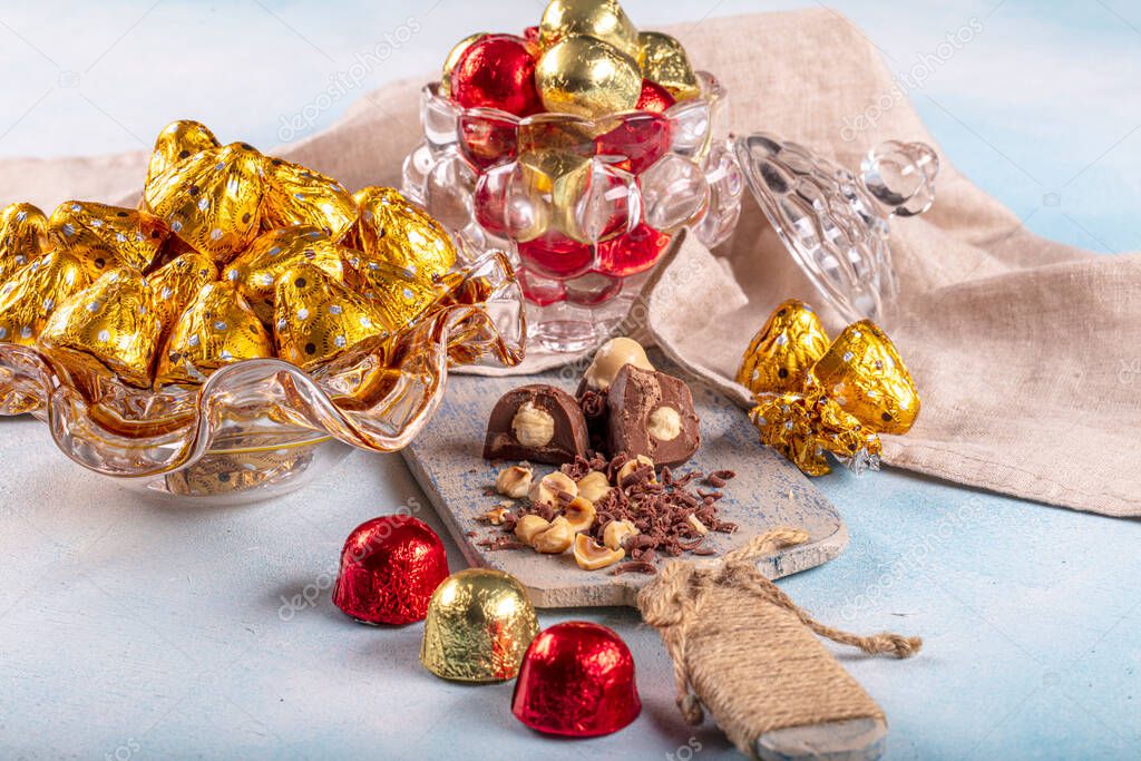 Chocolate candy in shiny wrapper. Delicious chocolate candies  on wooden background. Ramadan Eid (Ramadan feast) Concept.